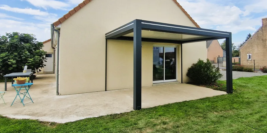 Pergola bioclimatique sombre adossée à la maison au-dessus de la terrasse