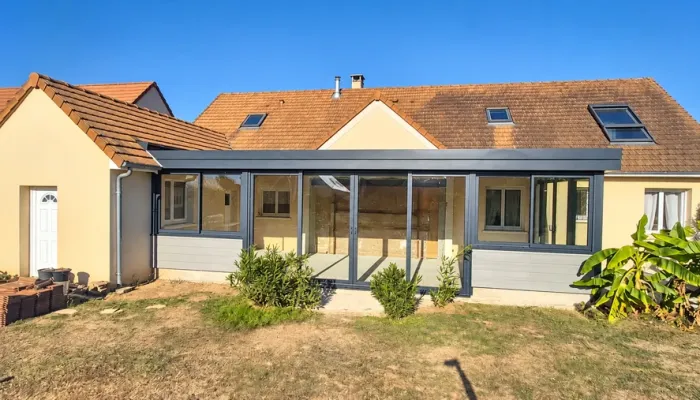Extension à toit plat près du Mans : façade vitrée et menuiseries gris foncé